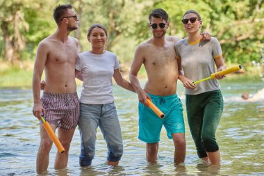 Bir grup mutlu arkadaş nehirde eğleniyor.