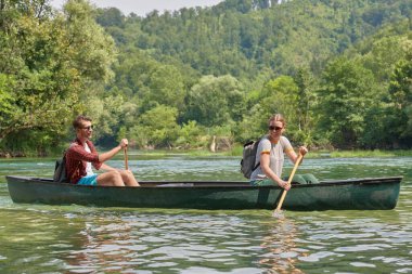Arkadaşlar vahşi bir nehirde kano yapıyorlar.
