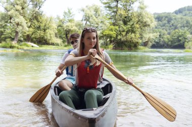 Arkadaşlar vahşi bir nehirde kano yapıyorlar.