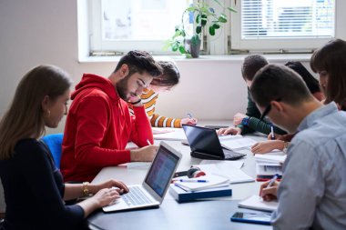 Modern üniversitenin tablet bilgisayarında okul projesi üzerinde çalışan öğrenciler grubu