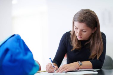 Öğrenci ders için not alıyor.