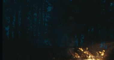 Yangın söndürme ekipmanları ve balta ile gece ormanda yangın söndüren itfaiyeci