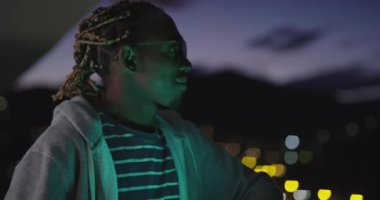 Neon ışıkları Afro-Amerikalı adamın üzerinde parti veriyor.