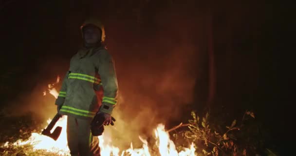 Retrato de bombero con equipo completo, sostiene el hacha en su mano — Vídeos de Stock