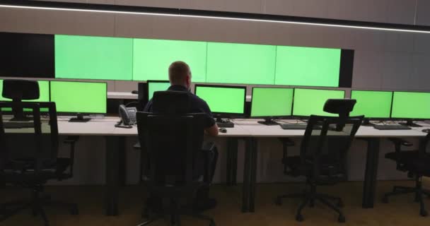 System Security Specialist werkt bij System Control Center. Kamer is vol met groene schermen, chroma scherm en beveiliging — Stockvideo