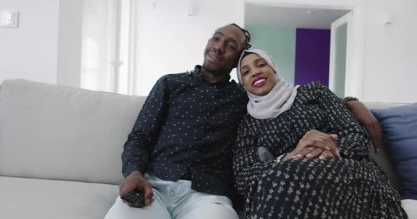 Casal africano no sofá no apartamento moderno assistindo tv — Vídeo de Stock