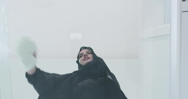 Młoda arabska muzułmanka w tradycyjnym stroju hidżabskim modląca się na szklanej podłodze — Wideo stockowe