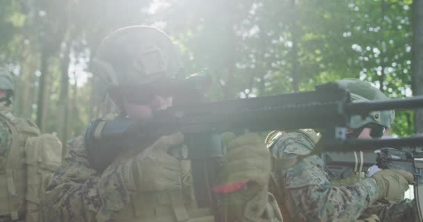 A katonák védik a vonalukat a sűrű erdőben. Az erdei bázis megmentésére és védelmére irányuló katonai fellépés — Stock videók