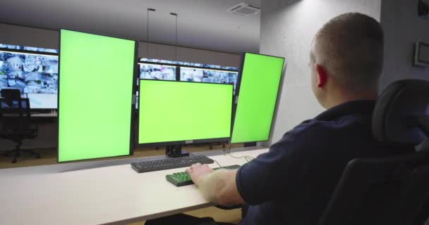 시스템 보안 전문가가 시스템 제어 센터에서 일하고 있습니다. 방은 녹색 스크린, 크로마 스크린 및 보안으로 가득 차 있습니다 — 비디오