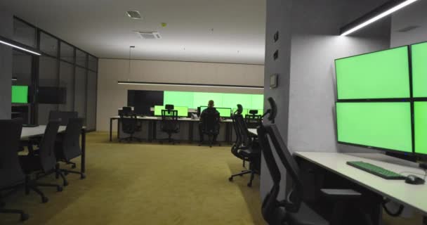 Tomma kontor, skrivbord och stolar på en stor CCTV säkerhetsdatacenter med grön skärm och kromnyckel — Stockvideo