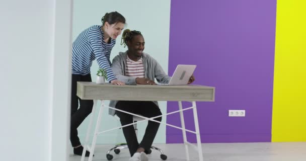 Positiv lächelnder Mann und Frau in der Nähe des Arbeitsplatzes mit Laptop im Büro — Stockvideo