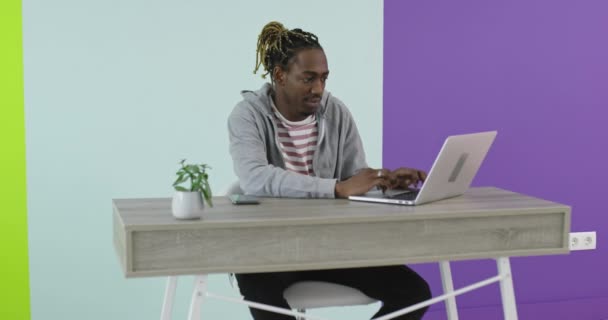 Afrykański biznesmen pracujący na laptopie siedzi w biurze — Wideo stockowe