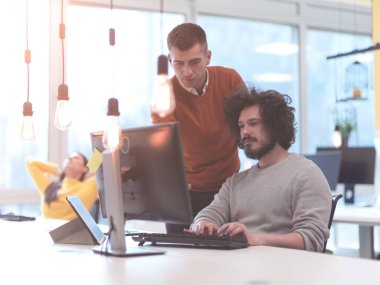 Yaratıcı iş adamları modern açık uzay ofisinde bağımsız olarak çalışıyor.