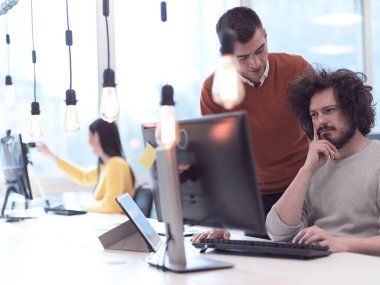 Yaratıcı iş adamları modern açık uzay ofisinde bağımsız olarak çalışıyor.