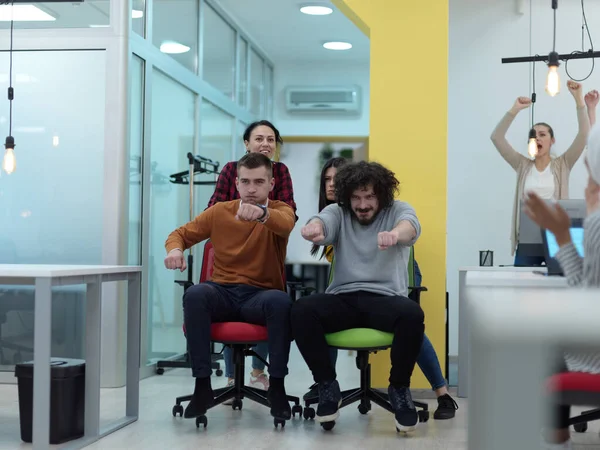 Grupo de startups multiétnicas en carrera de silla de oficina —  Fotos de Stock