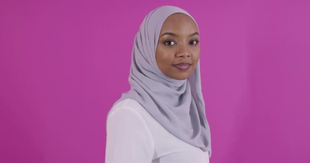 Portrait de jeune afro-musulman moderne portant des vêtements islamiques traditionnels sur fond plastique rose — Video