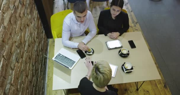 Młodzi biznesmeni siedzący w kawiarni rozmawiający i cieszący się najlepszym widokiem — Wideo stockowe