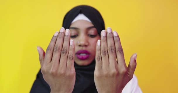 Vacker afrikansk amerikansk flicka bär muslim hijab över färg bakgrund — Stockvideo