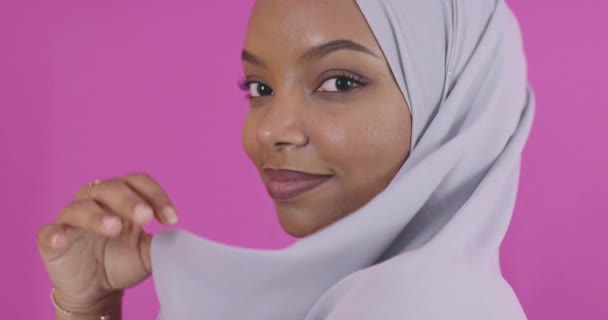 Portret młodego współczesnego muzułmanina afro piękna noszącego tradycyjne islamskie ubrania na plastikowym różowym tle — Wideo stockowe