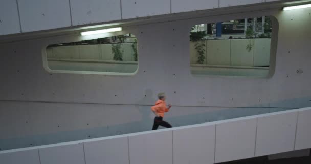 Mulher ativa correndo no centro da cidade à noite em ambiente urbano — Vídeo de Stock