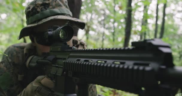 Fully equipped rifle soldier wearing camouflage uniform attacking enemy, rifle in firing position in dense forest — Stock Video