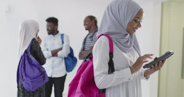 Afrikanische Studentin mit einer Gruppe von Freunden im Hintergrund, die traditionelle islamische Hijab-Kleidung tragen — Stockvideo