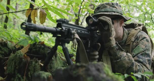 Voll ausgerüstete Gewehrsoldaten in Tarnuniform greifen Feinde an, Gewehr in Schießposition im dichten Wald — Stockvideo