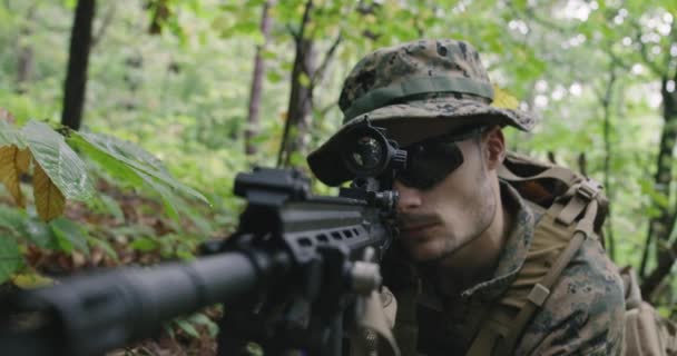 Tam teçhizatlı asker kamuflaj üniforması giyip düşmana saldırıyor, yoğun ormanda tüfeği ateşliyor. — Stok video