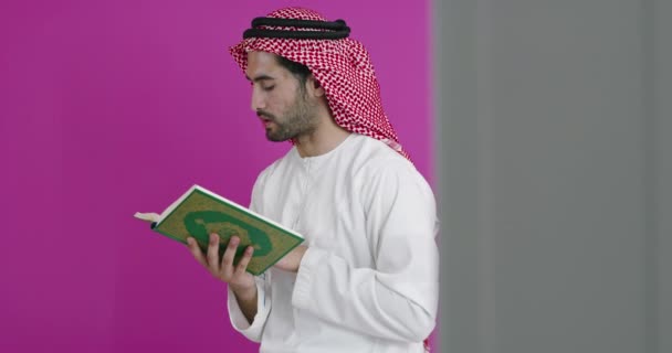 Mladý arabský muslim muž v tradičním oblečení modlí čtení Koránu — Stock video