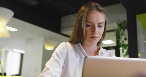 Mujer de negocios sonriente startup usando tableta mientras está de pie en la oficina minimalista — Vídeos de Stock