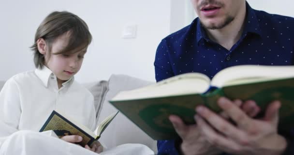 Muslim father and son reading from the Quran — Stock Video