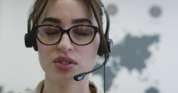 Close up of beautiful young operator woman standing and wearing headset at the bright office space — Stock Video