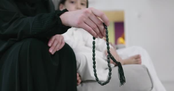 Μουσουλμάνα γυναίκα προσεύχεται στο σπίτι με παιδί στο βάθος — Αρχείο Βίντεο