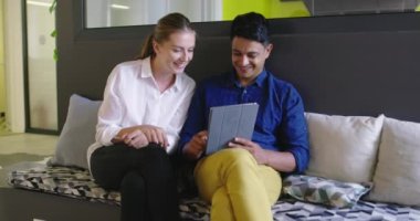 Toplantıda tablet bilgisayar kullanan iki kişi ile Stratup Şirketi