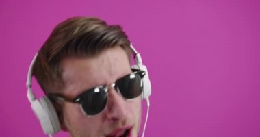 Müzik dinlerken dans eden ve gülümseyen bir adam.