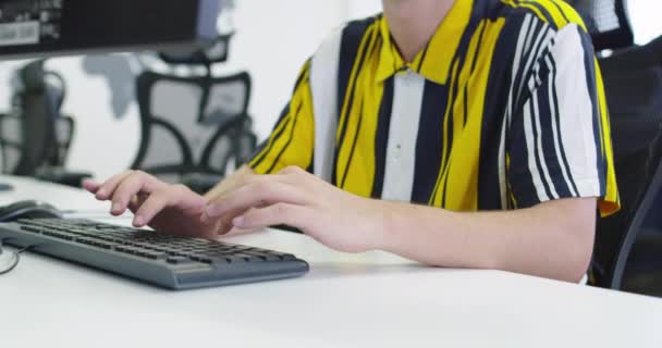 Affärsman som arbetar vid sin stationära dator sitter vid sitt skrivbord i det öppna utrymmet start kontor — Stockvideo