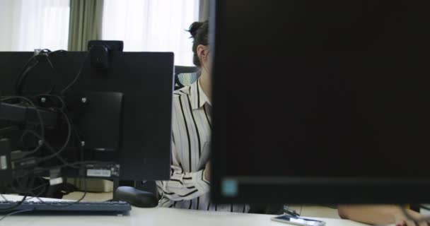 Концентрированный бизнесмен смотрит на монитор компьютера, работает в офисе стартапа — стоковое видео