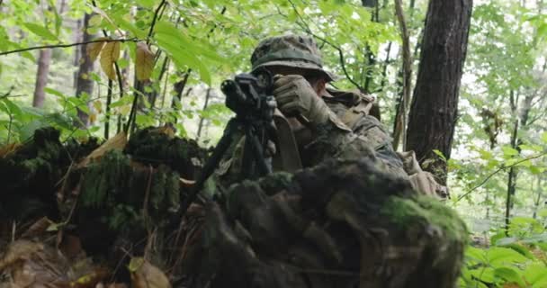 Soldado de espingarda totalmente equipado usando uniforme de camuflagem atacando inimigo, rifle em posição de disparo na floresta densa — Vídeo de Stock