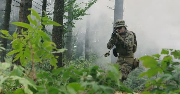 Soldiers in the smoke moving in battle operation thorugh dense forest — Stock Video