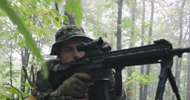 Soldato fucile completamente equipaggiato con uniforme mimetica che attacca il nemico, fucile in posizione di tiro nella fitta foresta — Video Stock