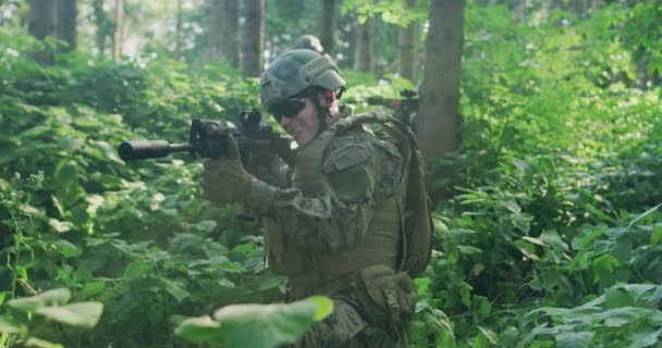 Soldados sosteniendo rifles emboscados en densos frentes durante el día, protegiendo la base con un equipo táctico completo — Vídeos de Stock