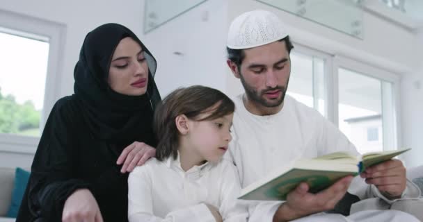 Muzułmańska rodzina czyta Koran i modli się razem na kanapie — Wideo stockowe