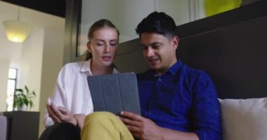 Toplantıda tablet bilgisayar kullanan iki kişi ile Stratup Şirketi