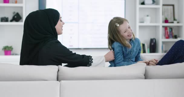 Famille musulmane à la maison jouer à des jeux sur le canapé avec leur enfant — Video