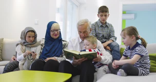 Familia musulmana generaciones abuelos leyendo el Corán con nietos en casa — Vídeo de stock