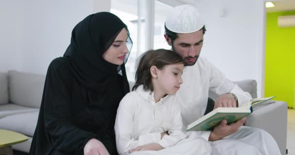 Мусульманська сім "я читає Коран і молиться разом на дивані — стокове відео