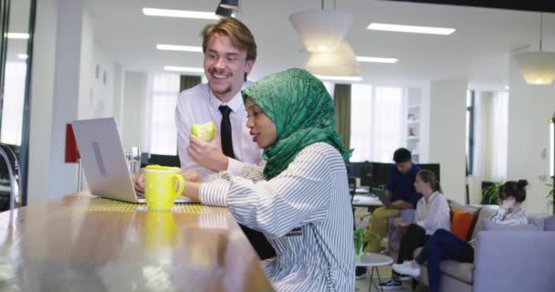 Mulher negra com hijab reunião homem de negócios no escritório de inicialização casual, homem comendo maçã na reunião — Vídeo de Stock