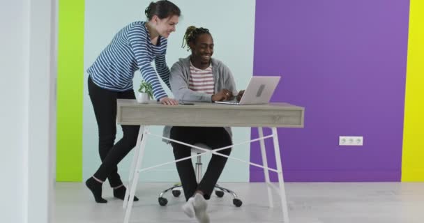 在工作场所附近，男人和女人都面带微笑，手提电脑也在办公室里合作 — 图库视频影像