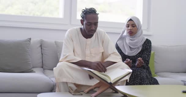 Africano casal muçulmano em casa no ramadã leitura Alcorão holly islamismo livro — Vídeo de Stock