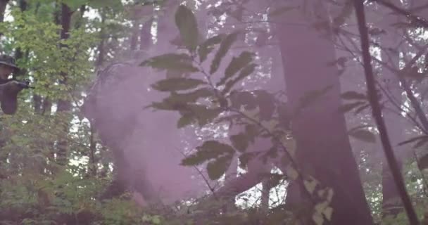 빽빽 한 숲 속에서 전투를 벌이고 있는 연기 속의 군인들 — 비디오